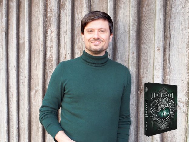 Fantasyautor Neo Helm mit dem Cover seines ersten Romans „Halbgott 1“