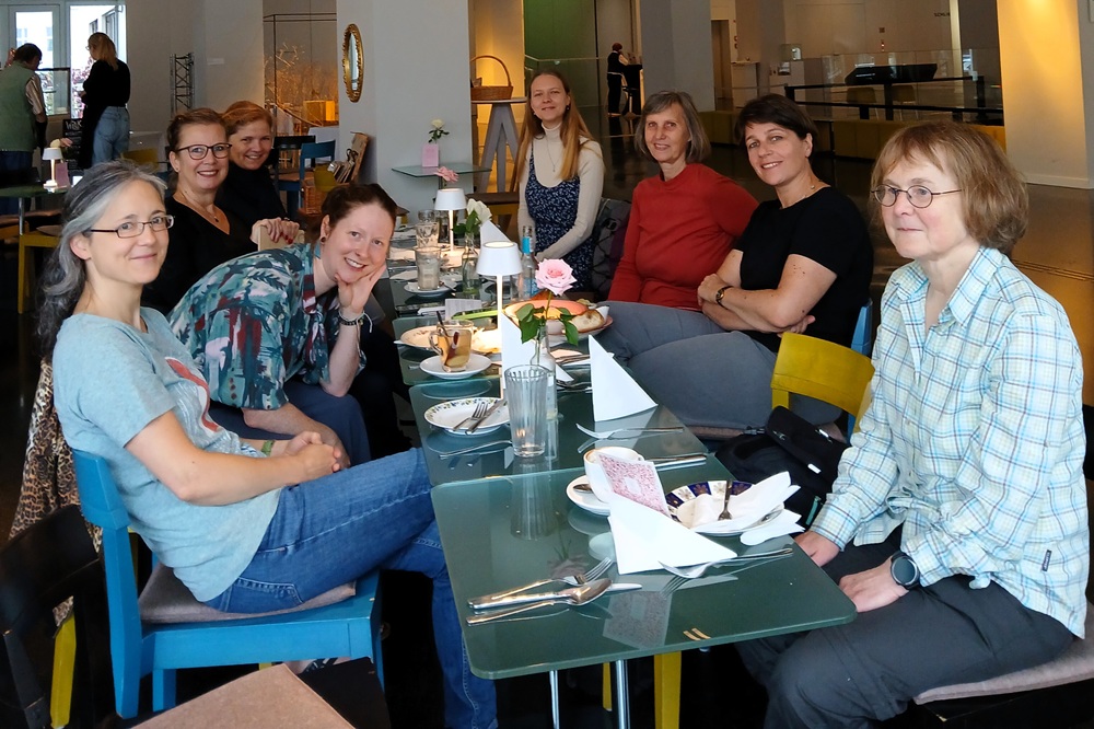 Die Mitglieder der RG Leipzig um einen Tisch im Café, das im ehemaligen Kaufhaus Schocken untergebracht ist