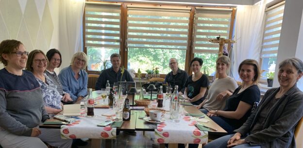 Die Regionalgruppe Rhein-Ruhr des VFLL um einen Tisch bei der Lesung von Peter Schäfer alias Neo Helm