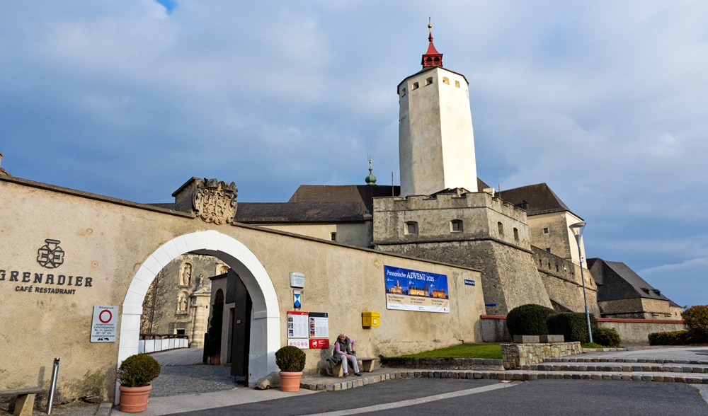 Trutzige, mittelalterich wirkende Burg Forchtenstein aus hellem Stein vor blauem Himmel