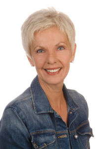 Porträtfoto Petra Teetz mit kurzem, weißblonden Haar und Jeansjacke. Schaut lächelnd in die Kamera