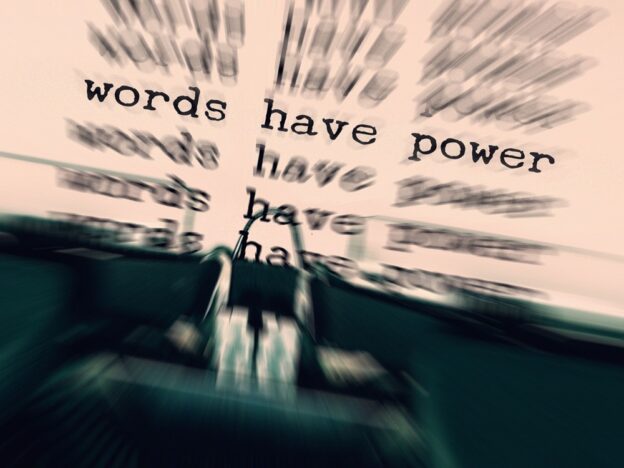 In eine Schreibmaschine ist ein Blatt eingeklemmt, auf ihm stehen die Worte "Words habe power". Durch einen Effekt ziehen sie sich nach onben und nach unten unscharf weiter, sodass die Botschaft sich wieder und wieder wiederholt